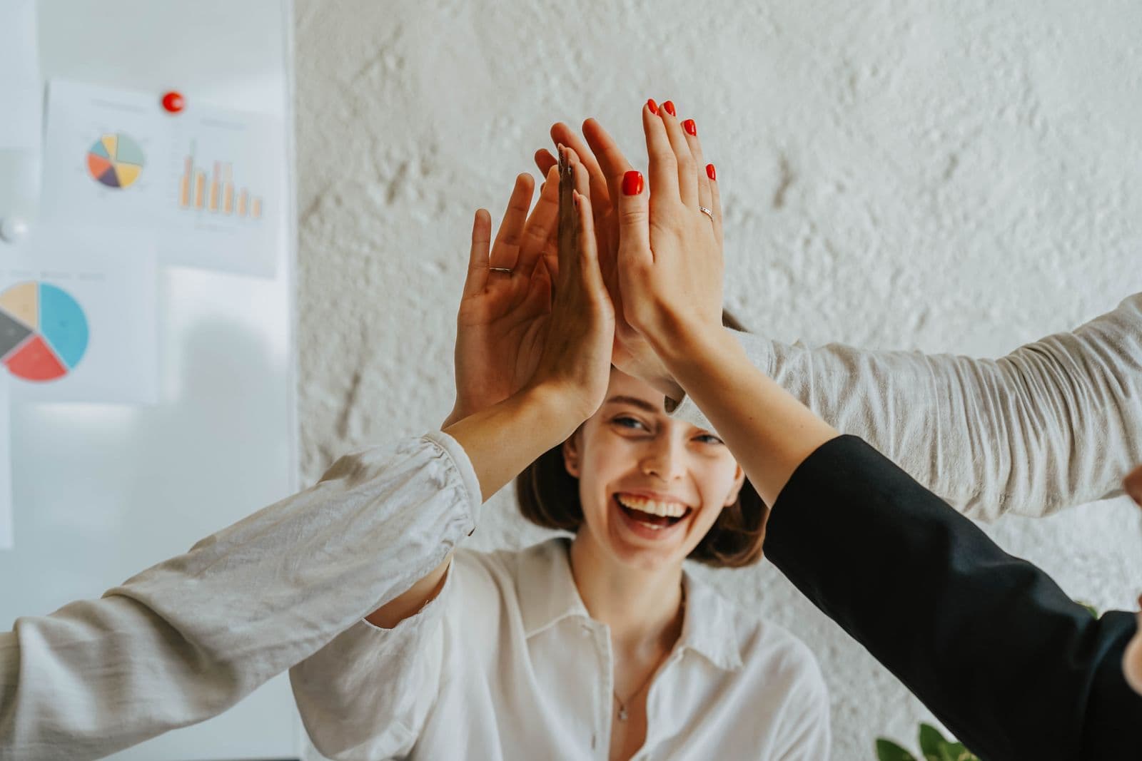 Collègues se donnant un high-five, célébrant un succès d'équipe